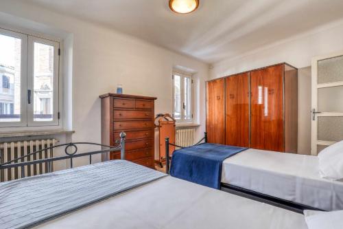 een slaapkamer met 2 bedden, een dressoir en ramen bij San Marco Casa Vacanza in Osimo