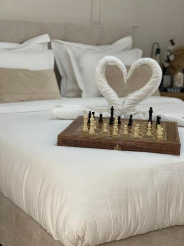 a chess board on a bed with a heart at Emanuel Suite in Eilat