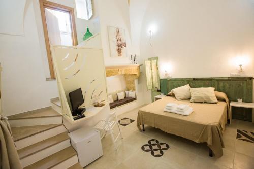 1 dormitorio con 1 cama y TV en una habitación en Capperi !! Holiday Rentals, en Morciano di Leuca