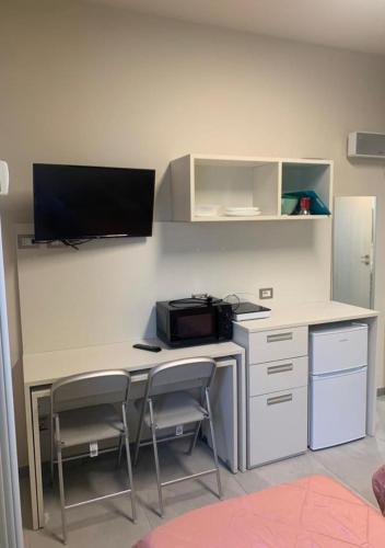 an office with a desk with a computer and two chairs at ARCOBALENO by DIMORA CHIC in Novara