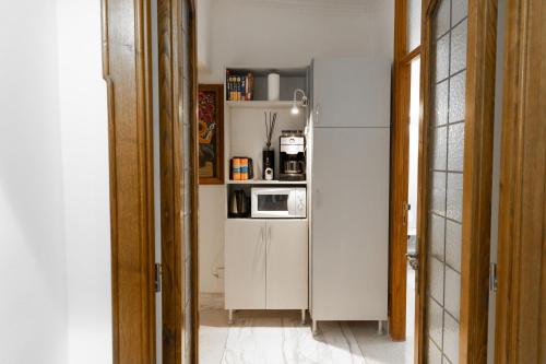 een keuken met een witte koelkast en een magnetron bij Domus Massimiliani Guesthouse in Rome