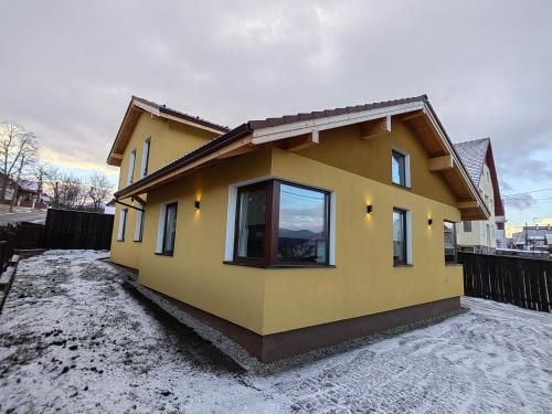 una casa amarilla con una ventana encima en Jegenye apartments, en Miercurea-Ciuc