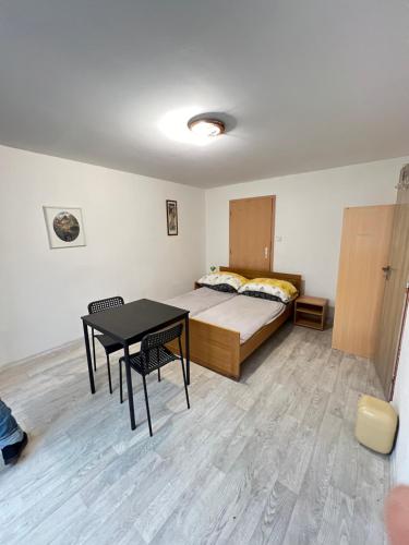 ein Schlafzimmer mit einem Bett und einem Tisch darin in der Unterkunft Ubytování Sýkora Apartments in Veľký Meder