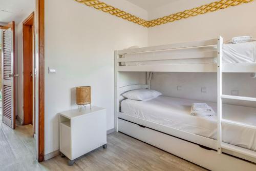1 Schlafzimmer mit 2 Etagenbetten und einem Tisch in der Unterkunft Lovely Apart with Balcony - Beach FL by LovelyStay in Cabanas de Tavira