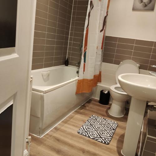 a bathroom with a toilet and a sink and a tub at Stunning 2-Bed Apartment in London Dagenham in Dagenham