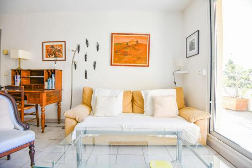 ein Wohnzimmer mit einem Sofa und einem Tisch in der Unterkunft Le Pharo - Plage des Catalans et métro Vieux-Port in Marseille