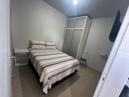 伊瓜蘇的住宿－Boicy Residence，小卧室配有带条纹毯子的床