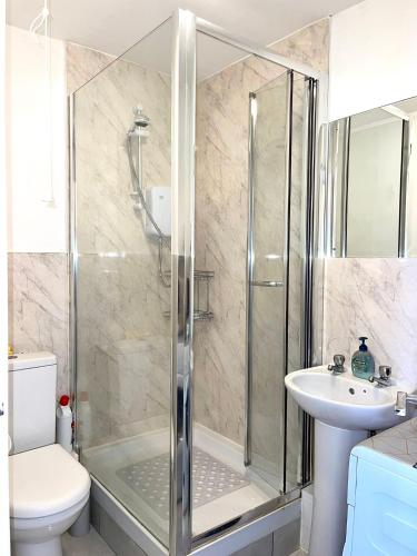 a bathroom with a shower and a toilet and a sink at Charming 1-Bed loft Apartment in Romford in Romford