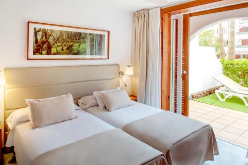 a hotel room with two beds and a balcony at Parque Santiago III Official in Playa de las Americas