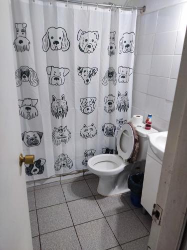 a bathroom with a shower curtain with dog faces on it at Hostal NF rocket in Los Ángeles