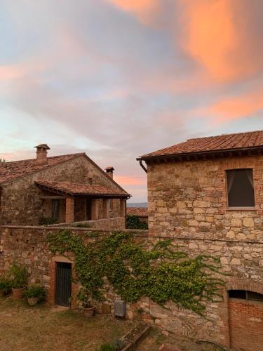 an old stone building next to another brick building at Borgo Montefreddo Toscana in San Casciano dei Bagni