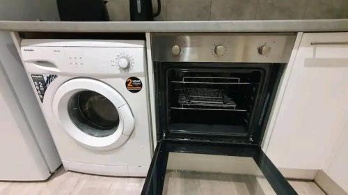 een witte wasmachine en droger in een keuken bij Entire apartment L B Haringey, Alexandra palace in Londen
