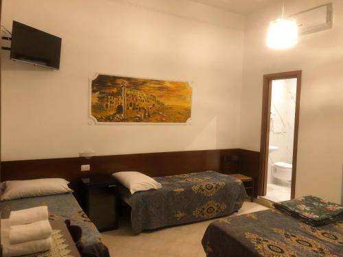 a room with two beds and a painting on the wall at Hostel Cosmos in Rome