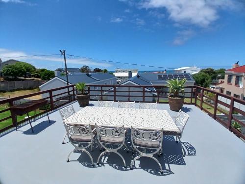 a white table and chairs on a balcony at Vergezicht Upper Unit in Franskraal