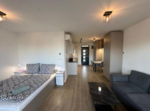 Habitación con cama, sofá y mesa. en Scamard Apartman, en Zamárdi
