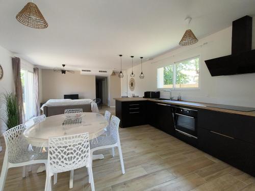 cocina y comedor con mesa y sillas en La Villa des Verdiers standing 6 personnes, en Andernos-les-Bains
