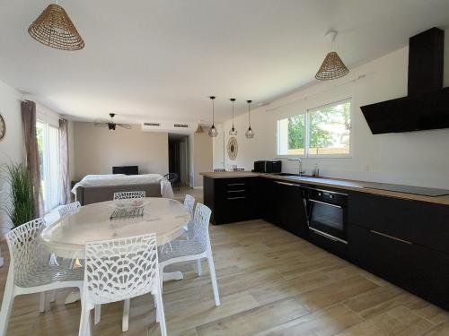 une cuisine et une salle à manger avec une table et des chaises dans l'établissement La Villa des Verdiers standing 6 personnes, à Andernos-les-Bains