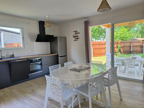 une cuisine et une salle à manger avec une table et des chaises dans l'établissement La Villa des Verdiers standing 6 personnes, à Andernos-les-Bains