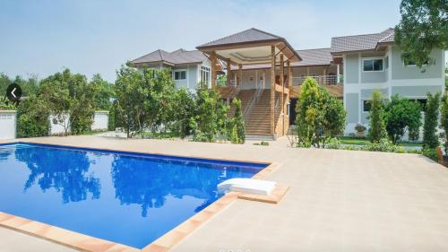 una casa con piscina frente a una casa en Baan Suan Khun Yaiy en Ban Wang Takhrai
