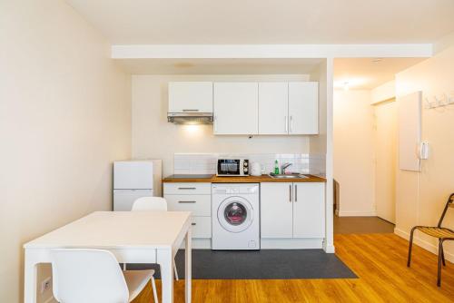 une cuisine avec des armoires blanches et une machine à laver dans l'établissement GuestReady - Lovely stay near Place de la Bastille, à Paris