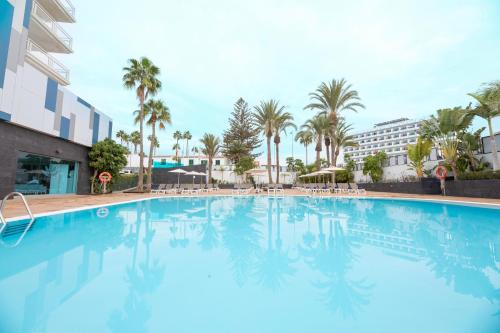 una gran piscina con palmeras y un edificio en Labranda Marieta - Adults only, en Playa del Inglés