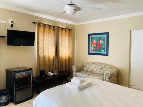 a bedroom with a white bed and a couch at St. Lucia Safari Lodge in St Lucia