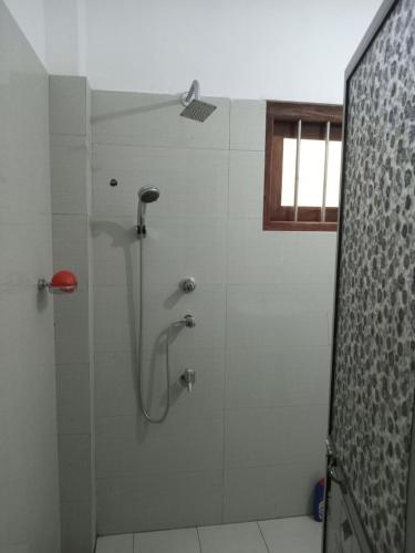 a bathroom with a shower with a glass door at Villa 147 in Hikkaduwa