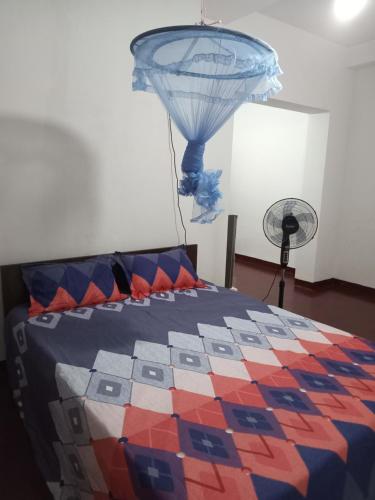 a bedroom with a bed with a colorful quilt at Villa 147 in Hikkaduwa