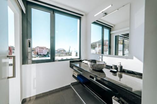 baño con lavabo y ventanas grandes en Eterna Primavera, en Adeje