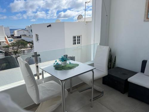 een kleine witte tafel en stoelen op een balkon bij Las Rosas Apartment (Adults Only) in Punta de Mujeres