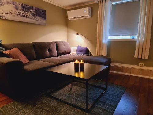 a living room with a couch and a coffee table at Kjellerleilighet egen inngang. in Stange
