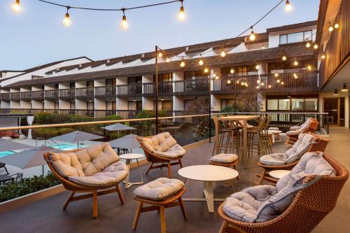 an outdoor patio with chairs and tables and a building at Hilton Garden Inn Monterey in Monterey