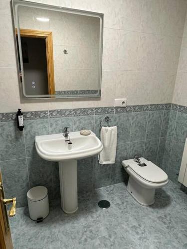 a bathroom with a sink and a toilet and a mirror at Apartamento 7 adultos in Rueda