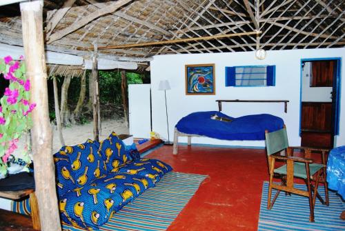 een kamer met een slaapkamer met een bed en een stoel bij Beach Bungalow 60sqm Fully serviced in Matemwe Zanzibar in Gazija