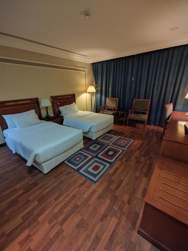 a hotel room with two beds and a desk at فندق كارم الخبر - Karim Hotel Khobar in Al Khobar