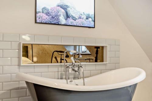 a bathroom with a sink and a bath tub at The Nook, Winchcombe in Winchcombe