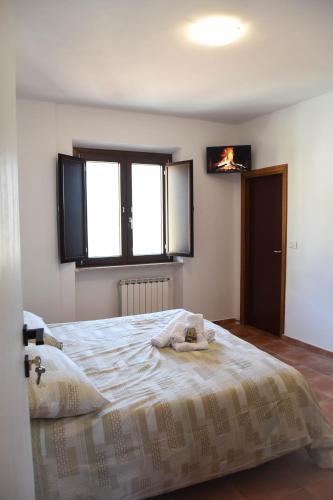 a bedroom with a bed and a tv on the wall at Affittacamere Ellera Verde in Villetta Barrea