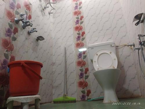 a bathroom with a toilet and a trash can at Hotel Rocks and pine Auli in Joshīmath