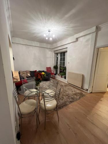 sala de estar con mesa, sillas y sofá en Double bedroom in chelsea en Londres