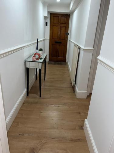 un pasillo con una mesa y una puerta en Double bedroom in chelsea en Londres