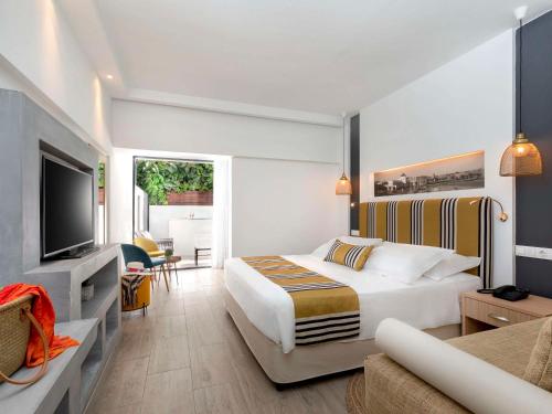 una camera d'albergo con letto e TV di Mercure Rhodes Alexia Hotel & Spa a Città di Rodi
