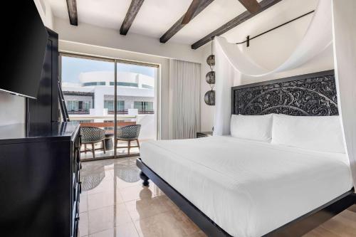 a bedroom with a white bed and a balcony at Hilton Vacation Club Cabo Azul Los Cabos in San José del Cabo