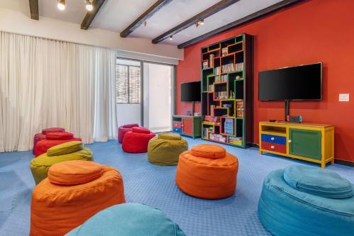 a living room with colorful chairs and a tv at Hilton Vacation Club Cabo Azul Los Cabos in San José del Cabo