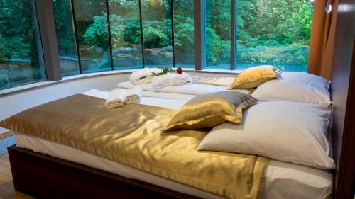 a large bed in a room with large windows at Rimske Terme Resort - Vila Sisi in Rimske Toplice