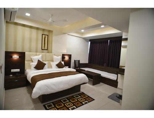 um quarto com uma cama grande e uma secretária em Hotel Royal Residency, Vadodara em Vadodara