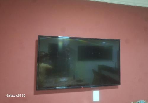 einen Flachbild-TV, der an einer Wand hängt in der Unterkunft Casa a 5 Minutos Da Praia in Armacao dos Buzios