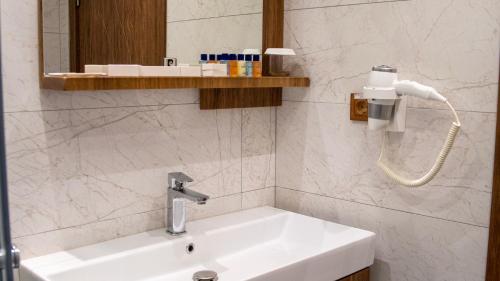 y baño con lavabo blanco y espejo. en Club Kavala Beach Hotel Assos, en Behramkale