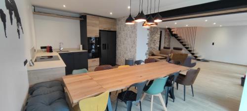 a dining room with a wooden table and chairs at GÎTE Les Cigognes N0ires in Dragey