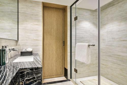 a bathroom with a shower and a sink at Hilton Garden Inn Wuhan Hankou in Wuhan