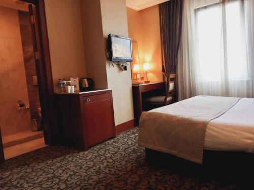 イスタンブールにあるDream Hill Business Deluxe Hotel Asiaのベッドとテレビが備わるホテルルームです。